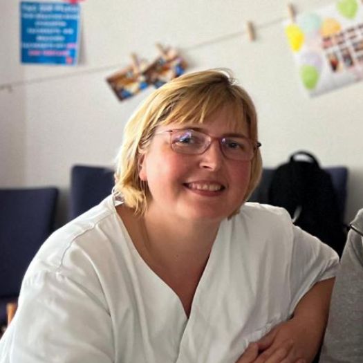 Katrin - Altenpflegerin im Krankenpflegeverein Schmiden Portrait einer jungen Frau, blond in einem weißen Kaftan, schaut freundlich in Kamerarichtung